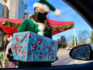 Holiday elf giving present through drivers window