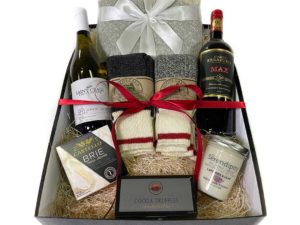 Box with wine bottles, candle, cheese, socks, and cocoa truffles